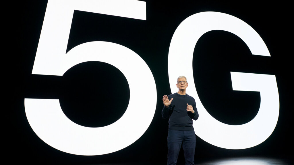 Auf diesem Bild sieht man Apples CEO Tim Cook, welcher auf der Bühne steht. Hinter ihm steht in großer weißer Schrift %G.